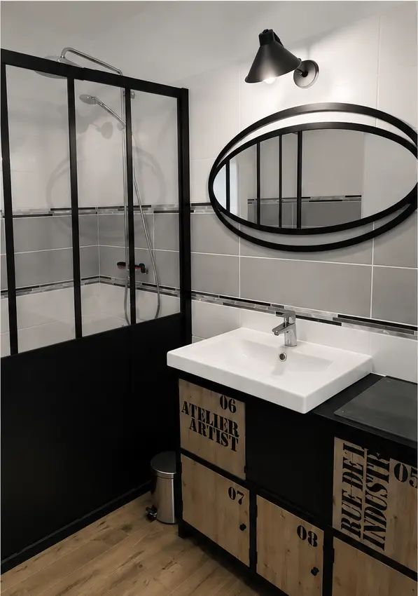 Salle de bain esprit loft avec verrière noire et meuble bois